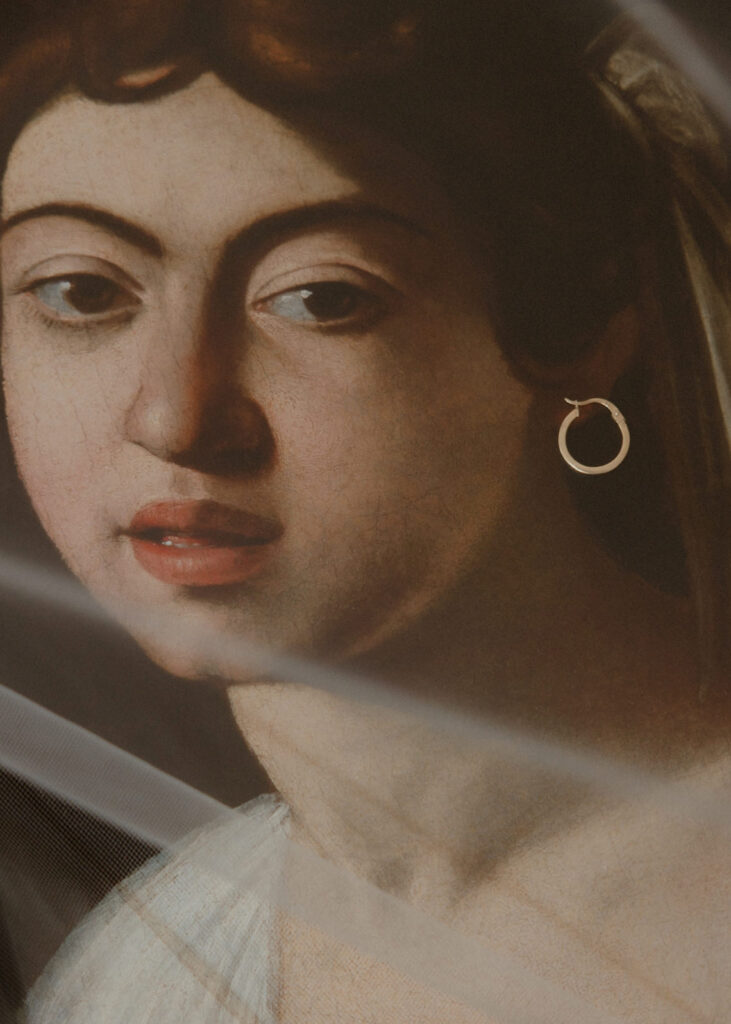 Bridal earring styled against a classical painting during a wedding in France