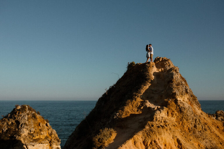 Couple standing on cliff top in the Algarve during engagement session