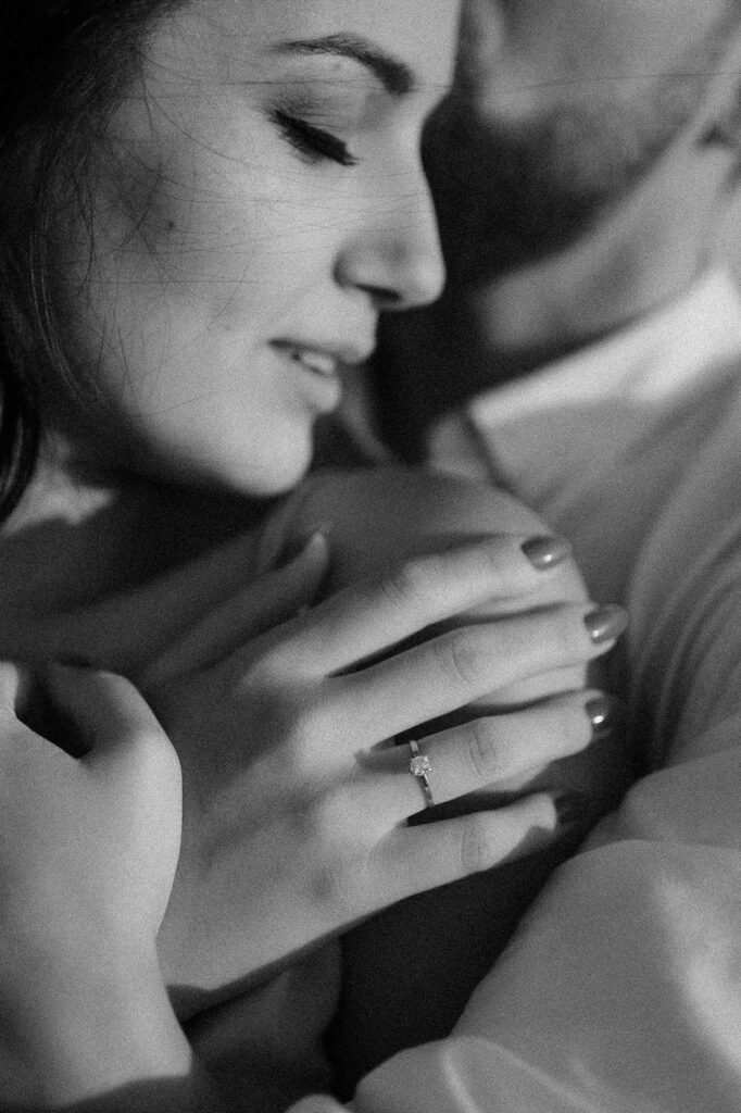 Close-up of a couple sharing an intimate moment with engagement ring visible on hand