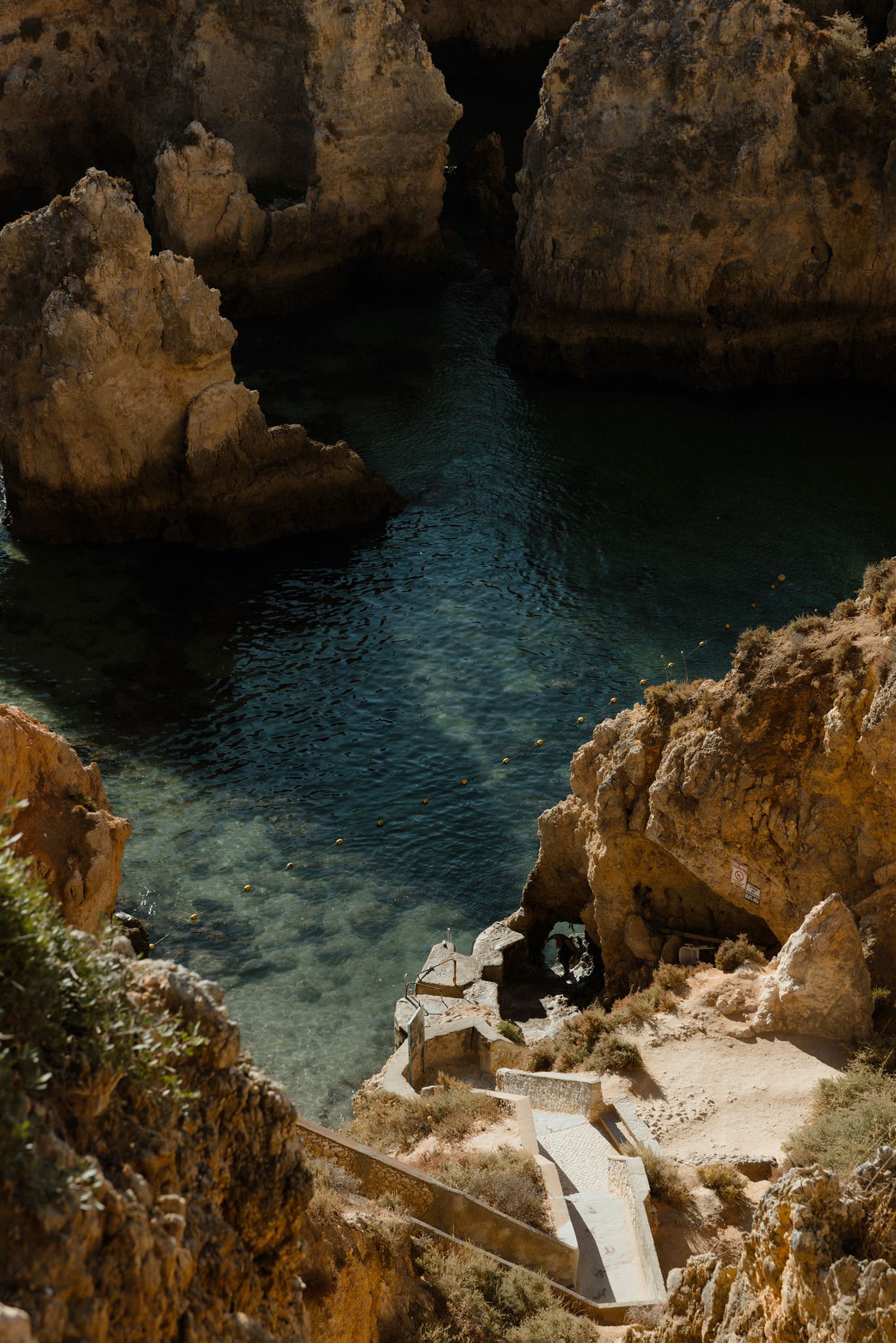 Hidden cove at Ponta da Piedade in the Algarve with golden cliffs and clear water below